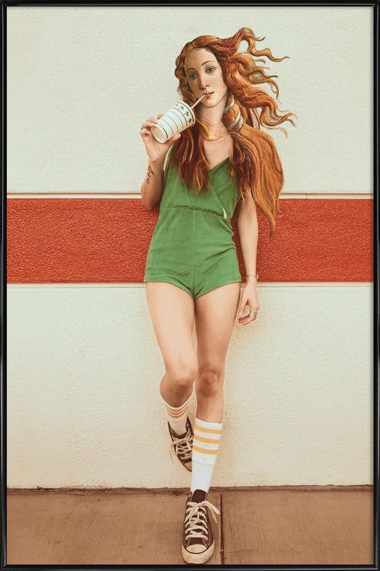 A woman with red hair wearing green shorts holds a cup, smiling as she enjoys her drink outdoors.